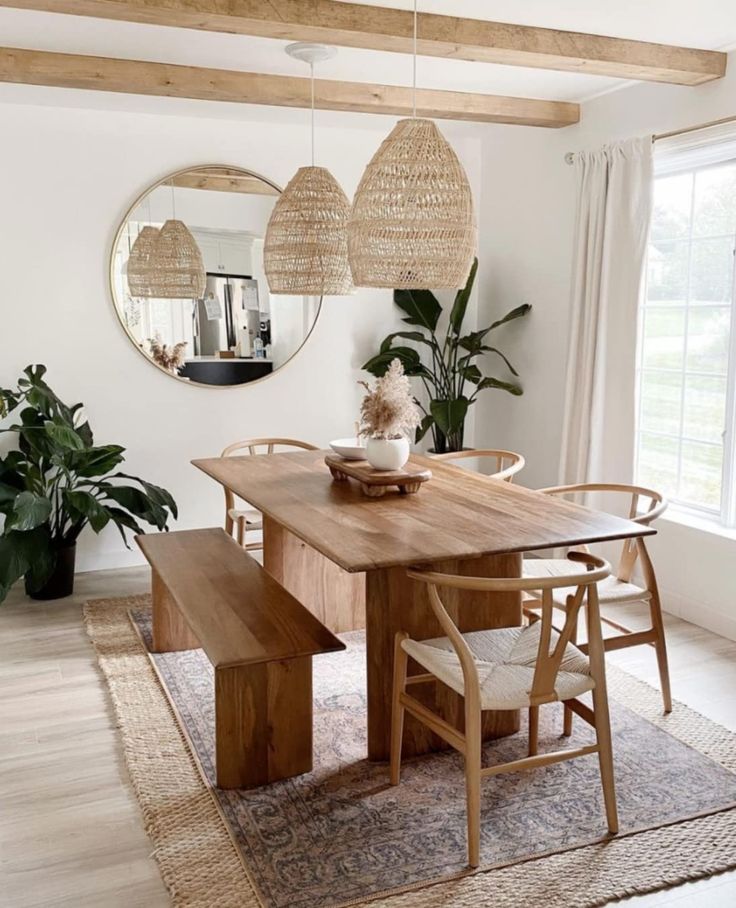 a dining room table with two chairs and a bench in front of a large window