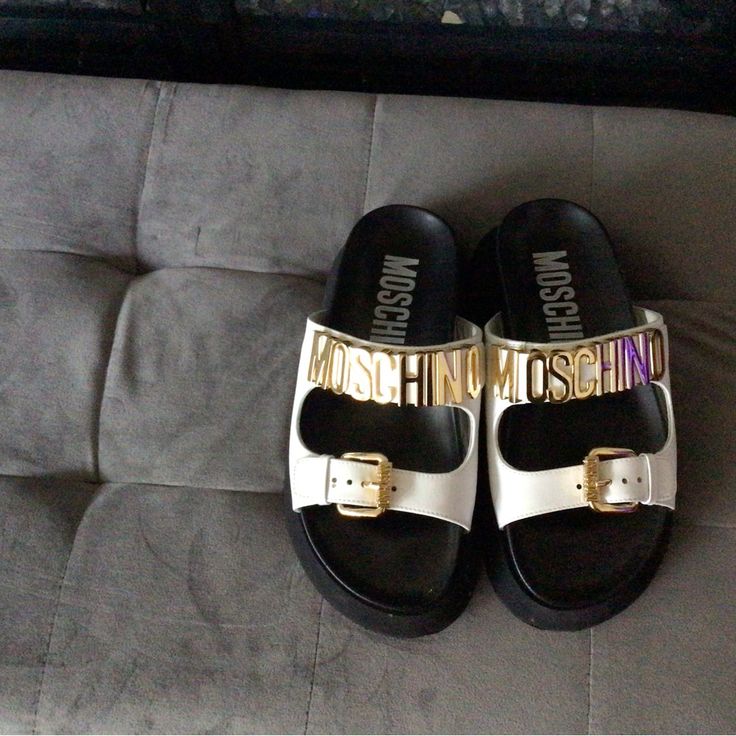 Perfect Brand New Condition. These Moschino Slides Are A Great Addition To Your Summer Wardrobe ! White Upper And Gold Hardware. Sz. 6.5 White Flat Slides With Buckle Closure, Trendy White Leather Slides, Designer White Sandals With Buckle Closure, Designer White Round Toe Sandals, White Flat Platform Slides, Chic White Flat Slides, Designer White Platform Sandals, White Platform Slides With Round Toe, Designer White Sandals With Leather Footbed