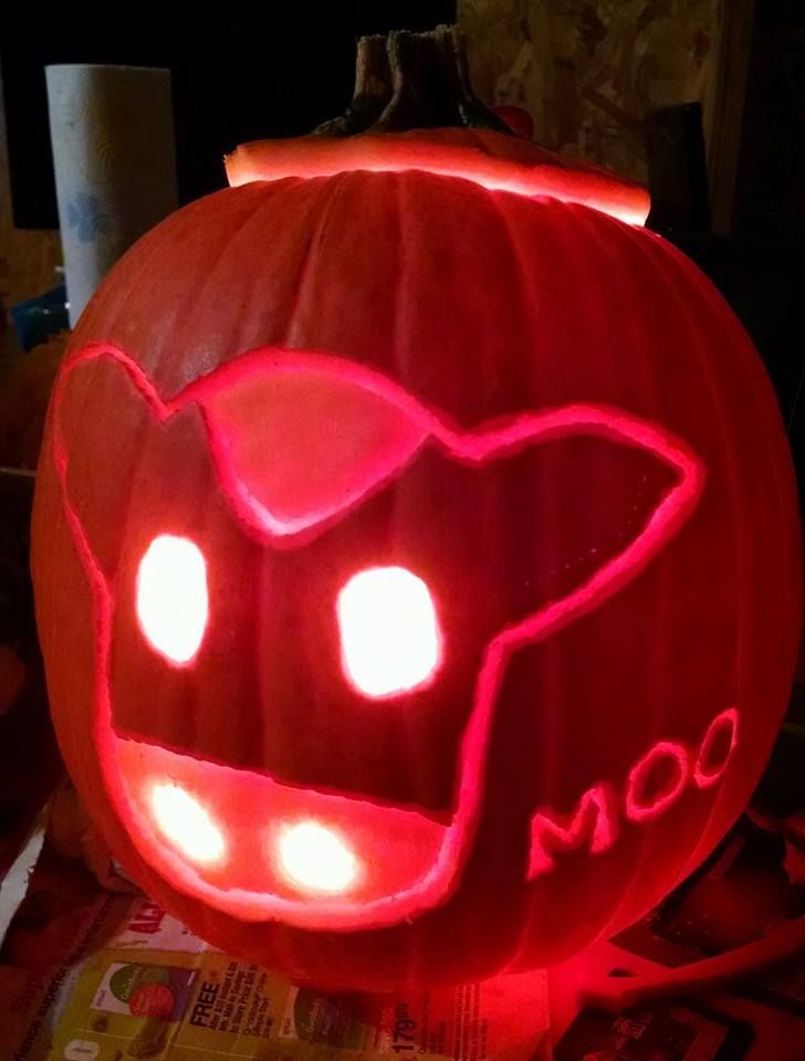 a pumpkin carved to look like an angry cat with glowing eyes and fangs on it