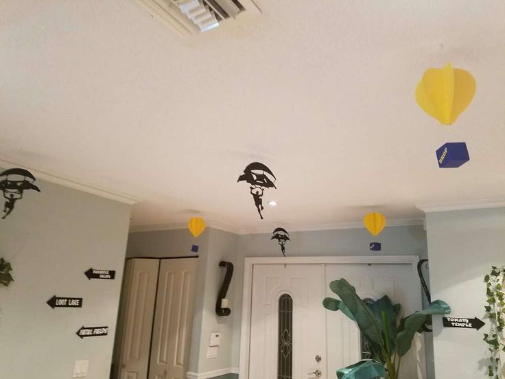 some yellow and blue hot air balloons are hanging from the ceiling in a room with white walls