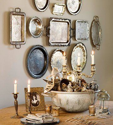 a dining room table with plates and candles on it, surrounded by other wall decorations