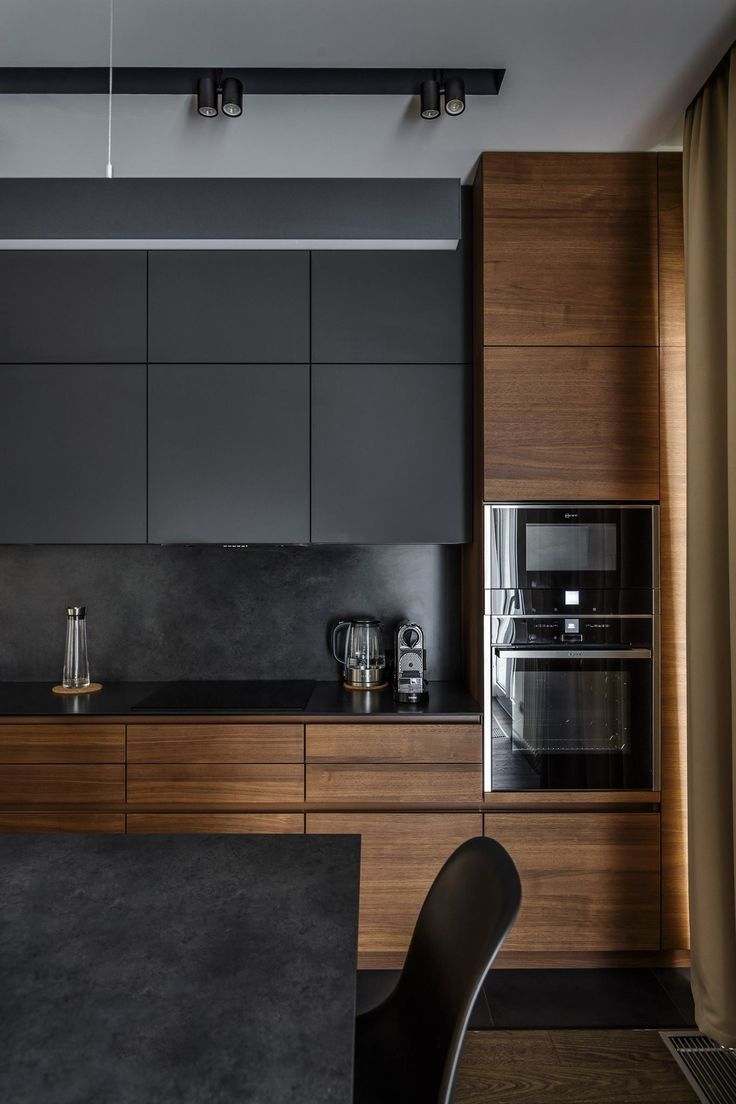 a kitchen with wooden cabinets and black counter tops, along with a stainless steel appliance