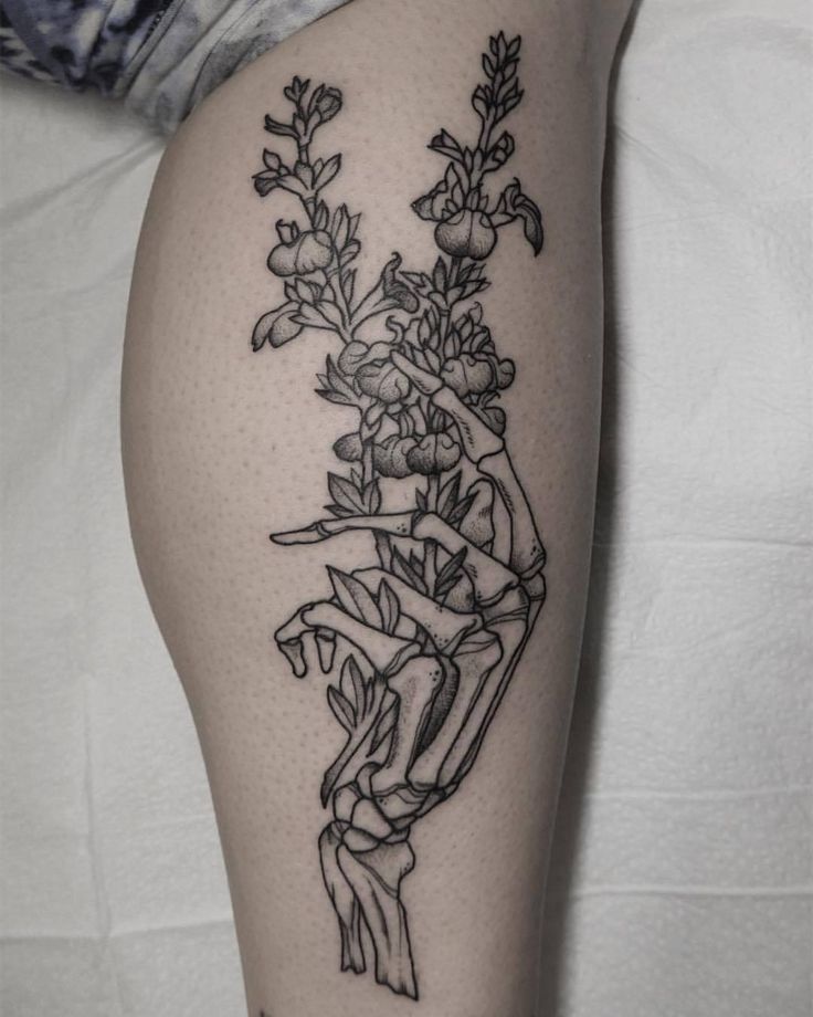 a black and white photo of flowers on the thigh