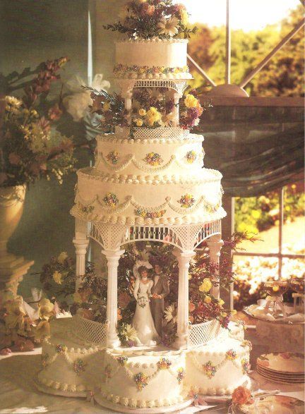 a wedding cake is decorated with flowers and figurines