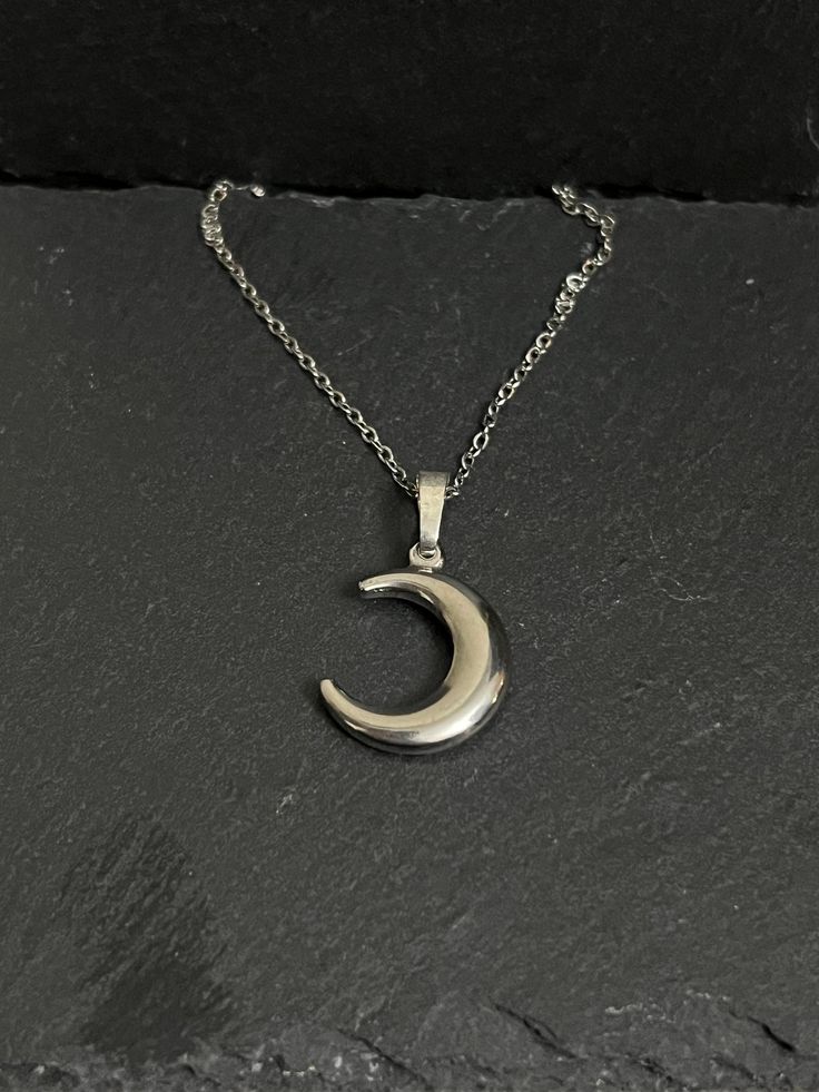 Crescent moon necklace hangs on stainless steel chain approx 18" Half Moon Metal Necklace For Gift, Half Moon Metal Necklace For Gifts, Silver Moon Charm Necklace With Adjustable Chain, Nickel Free Half Moon Silver Necklace, Silver Crescent Necklace With Adjustable Chain, Nickel-free Silver Half Moon Necklace, Nickel-free Silver Half-moon Necklace, Silver Half Moon Charm Necklaces, Silver Half Moon Charm Necklace