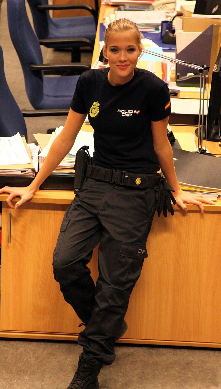 a woman sitting on top of a wooden desk