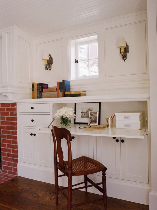 a chair sitting in front of a fire place next to a brick fireplace and bookshelf