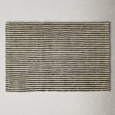 a black and white striped rug on the wall