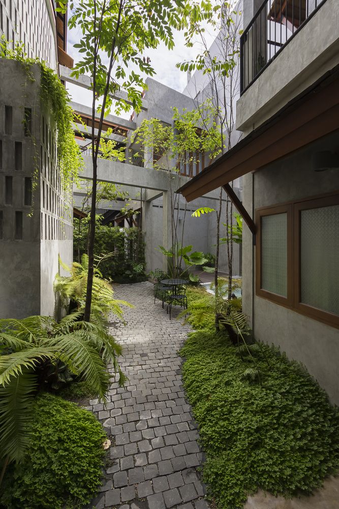 the walkway is lined with green plants and trees