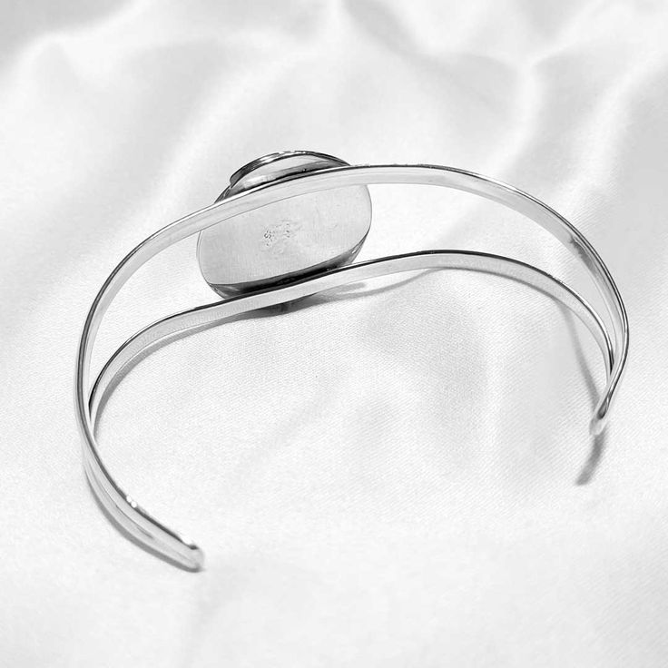 The exquisite Amira Bracelet is crafted from silver with a gorgeous spiral design. A stunning green jade center piece adds just the right finishing touch for a truly eye-catching piece. Veined green jade (16mm) Sterling silver (925) Elegant Silver Spiral Cuff Bracelet, Elegant Silver Spiral Bangle, Elegant Oval Cabochon Cuff Bracelet, Elegant Sterling Silver Spiral Bracelet For Gift, Elegant Spiral Sterling Silver Bracelets, Sterling Silver Cabochon Bracelet As A Gift, Silver Bangle Bracelet For May Birthstone, Elegant Silver Cabochon Bracelets, Green Sterling Silver Round Cuff Bracelet