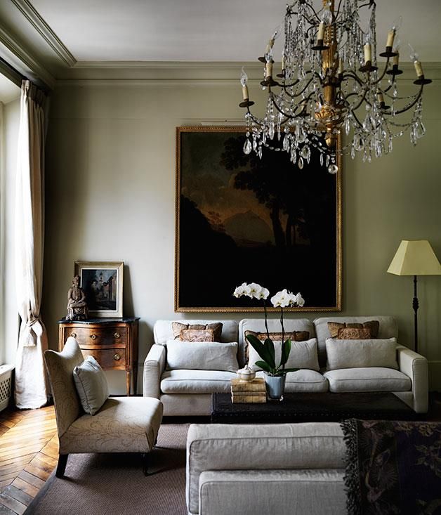 a living room filled with furniture and a chandelier hanging over it's head