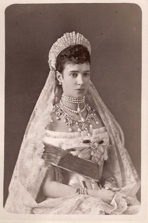 an old black and white photo of a woman wearing a tiara