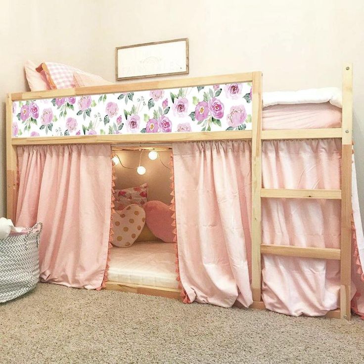 there is a bunk bed with pink curtains on it