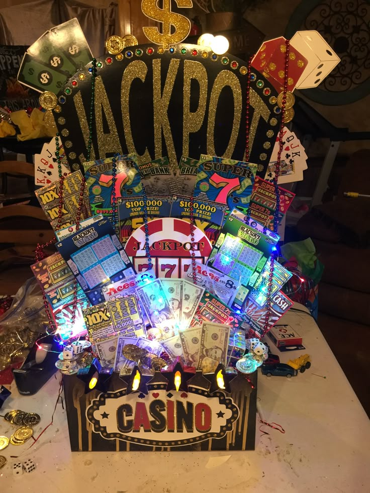 a casino themed birthday centerpiece with candles and cards on it's sides, sitting on a table