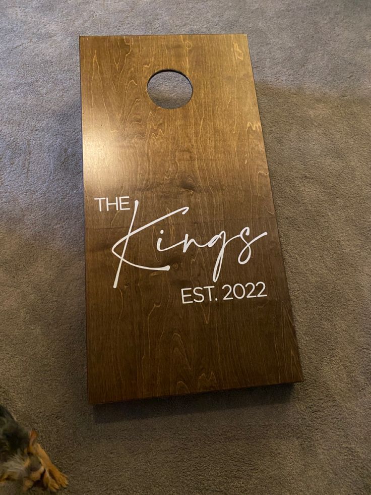 a personalized cornhole board with the king's est 202 written on it