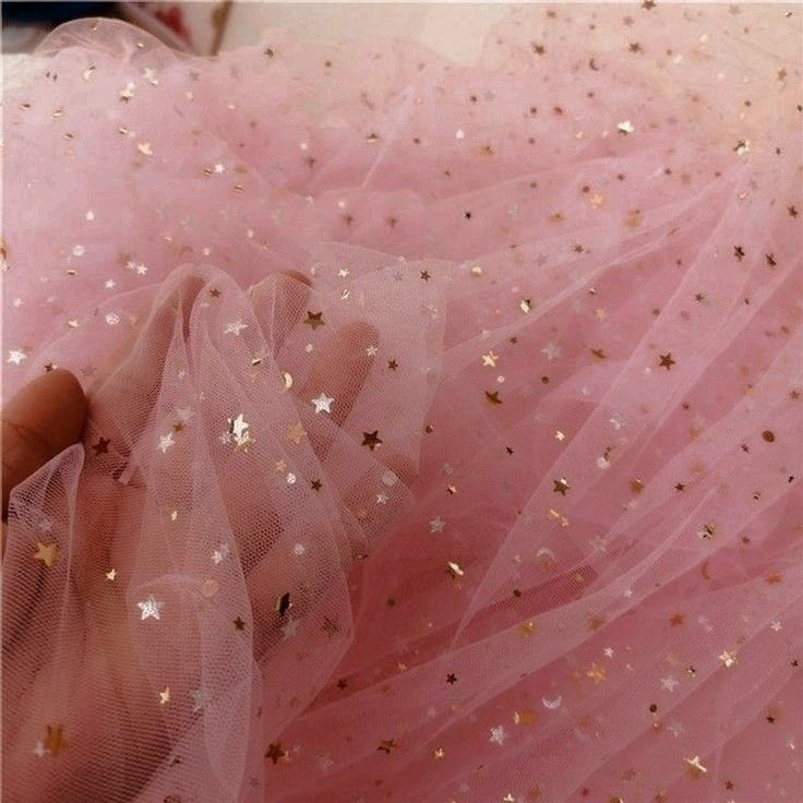 a woman wearing a pink dress with stars on it