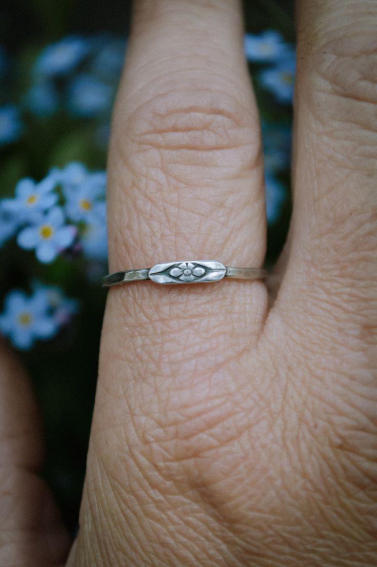 These hand hammered sterling silver stacking bands feature the sweetest little forget me not flower. Don't forget to chose your size at checkout. This piece is made to order by me in my studio in Massachusetts. Please allow up to three weeks turn around time for your piece to be made. Please ask any and all questions before purchasing. I'm happy to answer them! This item is handmade, there may be slight variations or imperfections. Dainty Sterling Silver Midi Rings For Promise, Delicate Tiny Stackable Rings For Gifts, Dainty Stackable Toe Rings For Promise, Dainty Hypoallergenic Stackable Promise Rings, Dainty Stackable Flower Ring As Gift, Delicate Flower Stackable Rings For Anniversary, Dainty Hand Stamped Stackable Rings For Anniversary, Delicate Tiny Sterling Silver Stackable Rings, Dainty Nickel-free Promise Ring