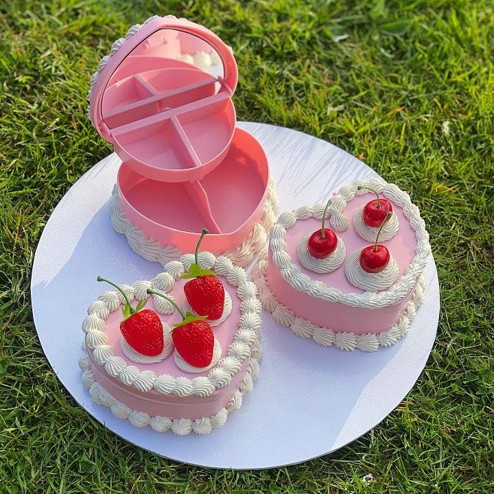 two heart shaped cakes on a plate with strawberries in the shape of strawberrys