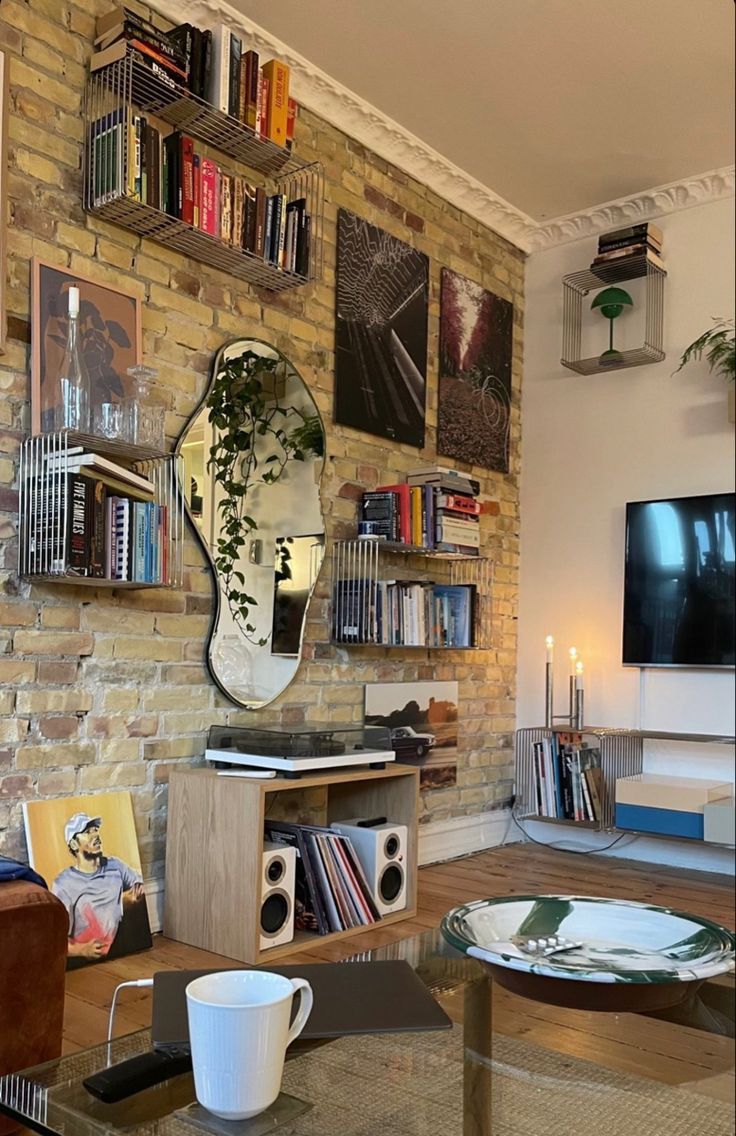 a living room filled with furniture and a flat screen tv mounted to a brick wall