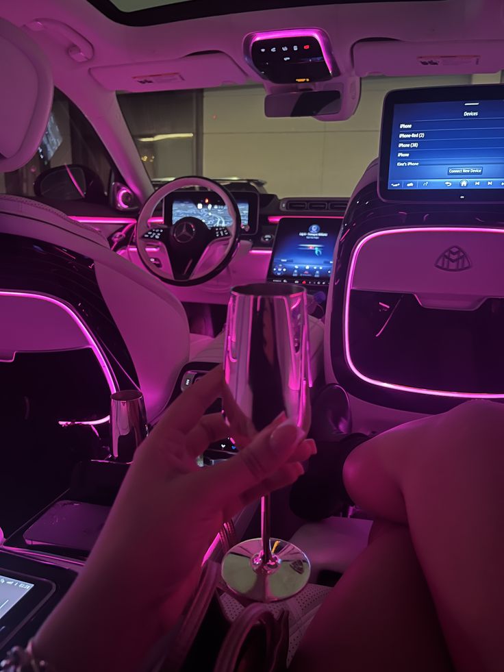 the interior of a car is lit up with purple lights and features electronic gadgets