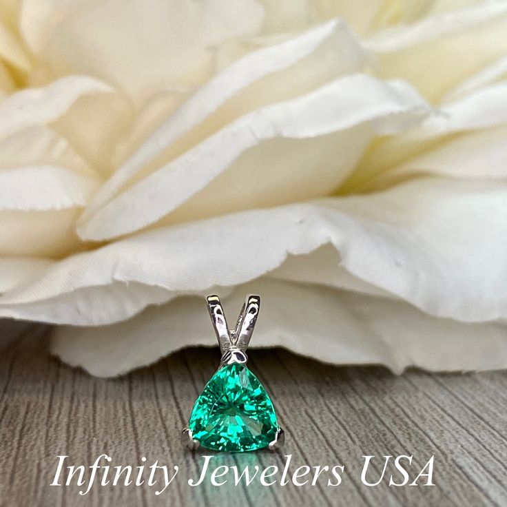 "The pendant pictured is a lab created emerald #6074 -Approximate total carat weight: approx. 1.80ctw diamond equivalent -Center Stone Size: 7x7mm - approx. 1.80ct diamond equivalent -Center Stone Shape: trillion -Gem Type: lab created emerald -Stone Clarity: VS2 -Stone Color: green -Moh's Scale: 8.5 hardness -Metal Type and Purity: 14k white gold -Setting: 3 prong basket head open back design -Chain: delicate 14k gold chain / heavier option with lobster claw available (use dropdown to select) - Trillion Cut Emerald Jewelry In Green, Trillion Cut Green Emerald Jewelry, Green Trillion Cut Emerald Jewelry, Gia Certified Trillion Cut Green Jewelry, Green Gia Certified Trillion Cut Jewelry, Fine Jewelry Emerald With Trillion Cut, Anniversary Emerald Necklace In White Gold With Vvs Clarity, Trillion Cut Emerald Jewelry In White Gold, Elegant Trillion Cut May Birthstone Jewelry