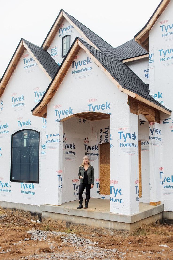 a man standing in the doorway of a house under construction