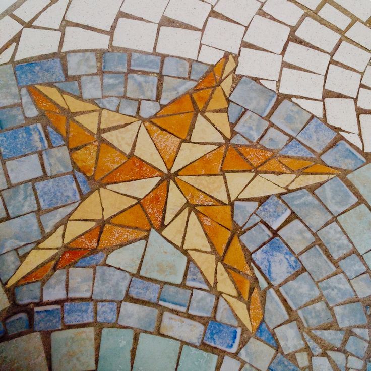 a star is painted on the ground with blue and orange tiles