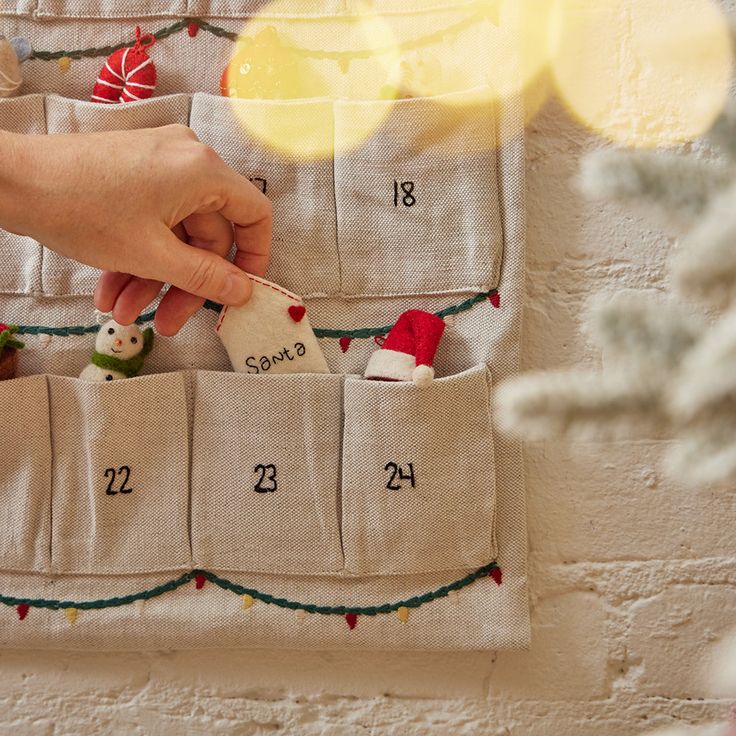 Celebrate the whole month of December with our festive one-of-a-kind advent calendar! Made in a lovely natural linen/cotton blend, it is inspired by some of our favorite Christmas motifs, the intricate details of holly, stars, lights, and berries will keep you merry for years to come! With an incredible attention to detail, this piece is an heirloom to last a lifetime! Hand-embroidered, made from 55% cotton/45% linen blend. Mini ornaments NOT included. Crafted with love by our artisans in India. Advent Calendar Pattern, Felt Advent Calendar, Christmas Motifs, Month Of December, Wrapping Gift Cards, Christmas Linen, Mini Ornaments, Christmas Advent Calendar, Hand Felted