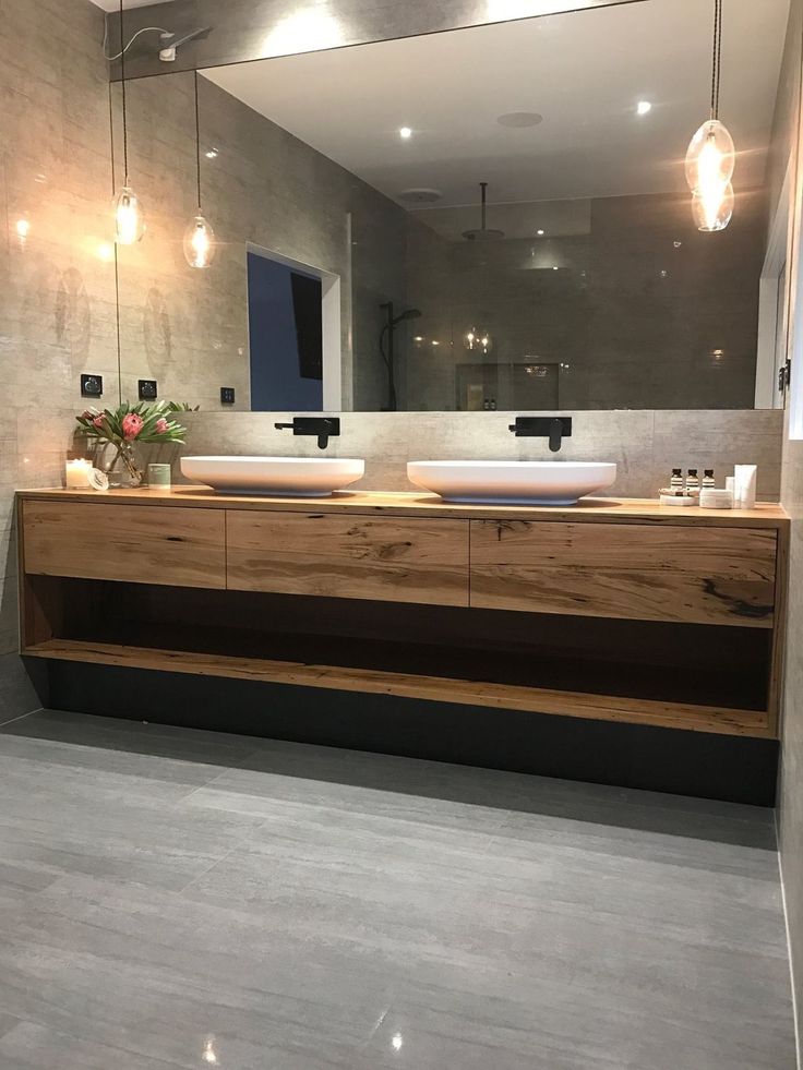 a bathroom with two sinks and a large mirror on the wall over it's counter