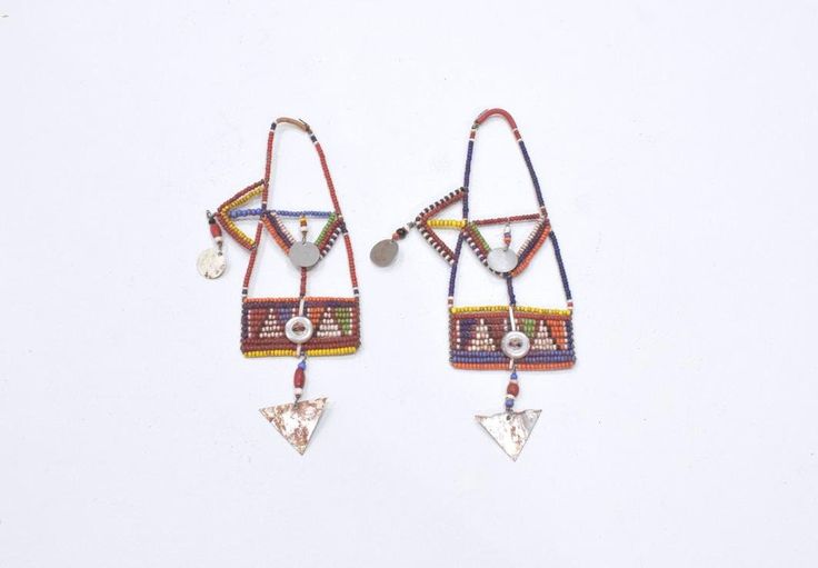 These African old tribal beaded earrings from the Masai Tribe of Kenya and would be a stunning addition to any jewelry collection. The intricate design and vibrant colors make them a true statement piece. The earrings are made from wire and beads and feature a unique aluminum metal. The earrings are collectors items and are perfect for both men and women. The main stone is glass and the ear area is the lobe. The beaded style and multicolor design are a beautiful representation of African ethnic and regional style of the Masai of Kenya. These earrings are a must-have for anyone who loves tribal jewelry. Museum Quality 6 1/4 Inches Long 3.5 Inches Wide Middle Top 2 Inches Wide Bottom Dangle 1.5 Inches Long AT BACARA WE STAND BEHIND ALL OF OUR MERCHANDISE. FULL MONEY BACK GUARANTEE WILL BE PR Traditional Multicolor Earrings With Polished Beads, Unique Beaded Earrings With Tiny Beads For Festivals, Traditional Round Beaded Earrings For Festival, Bohemian Beaded Earrings With Colorful Beads, Unique Tiny Beaded Earrings For Festival, Unique Festival Earrings With Tiny Beads, Bohemian Polished Bead Drop Earrings, Bohemian Polished Beaded Drop Earrings, Artisan Earrings With Tiny Beads For Festival