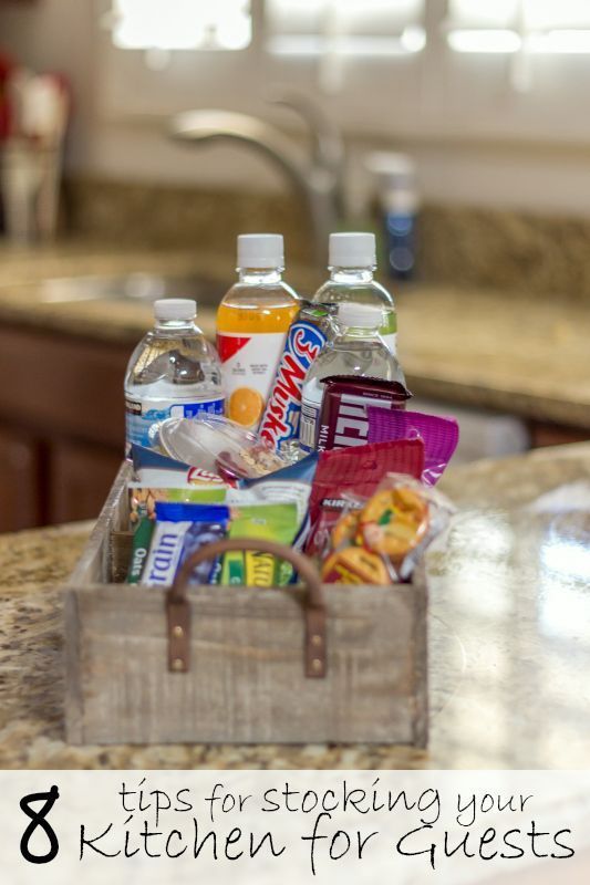 a kitchen counter with an open suitcase filled with food and drinks on it, next to the words 8 tips for stocking your kitchen for guests