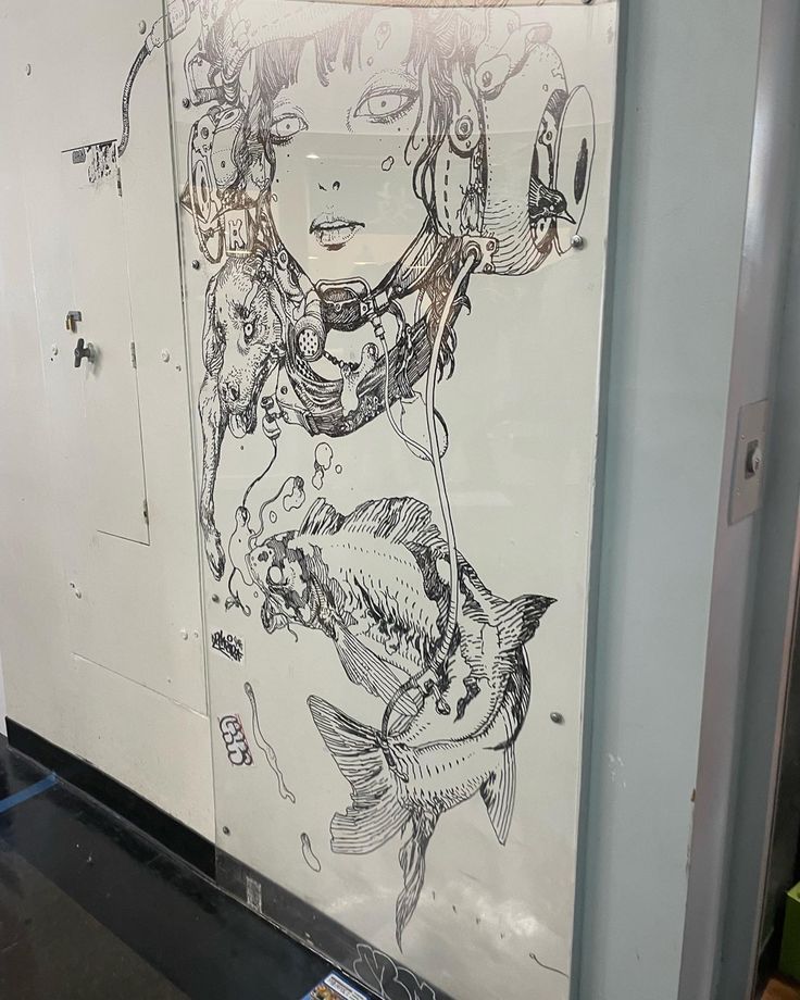 a drawing of a woman's face and fish on a whiteboard in a room