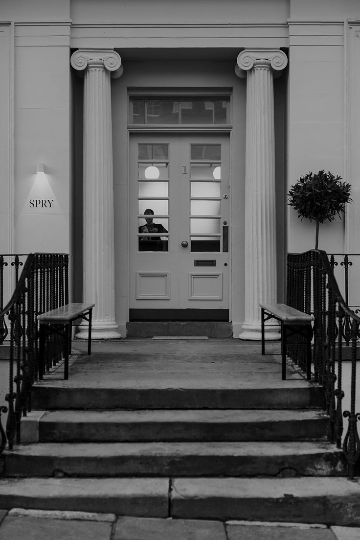 black and white photograph of steps leading up to a door with columns on either side