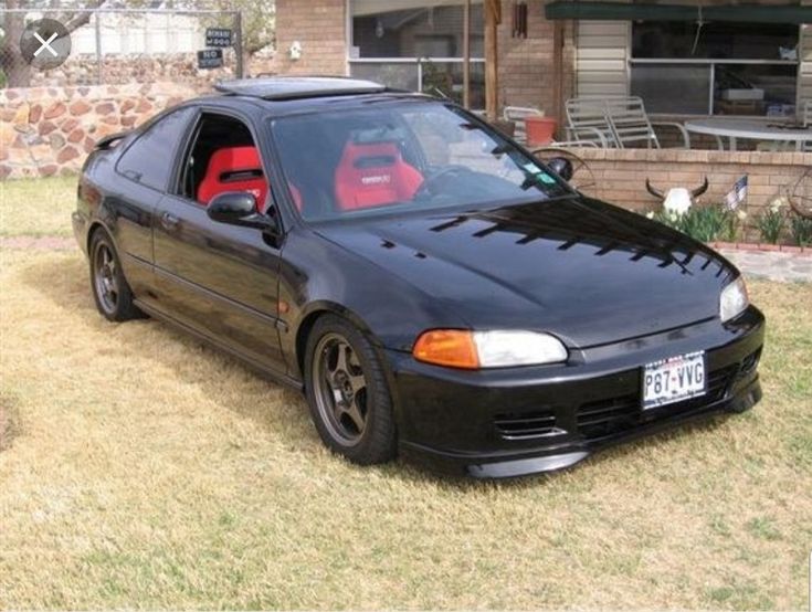 a black car parked in front of a house