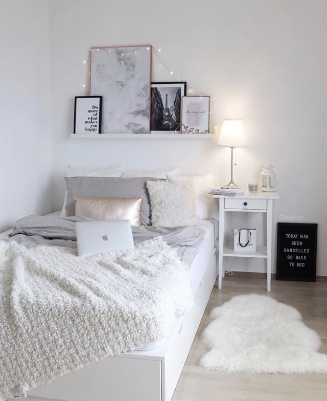 a bedroom with a bed, desk and laptop on the table in front of it