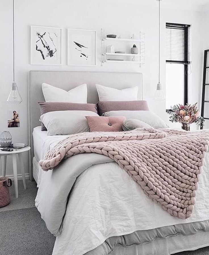 a bed with white sheets and pink blankets