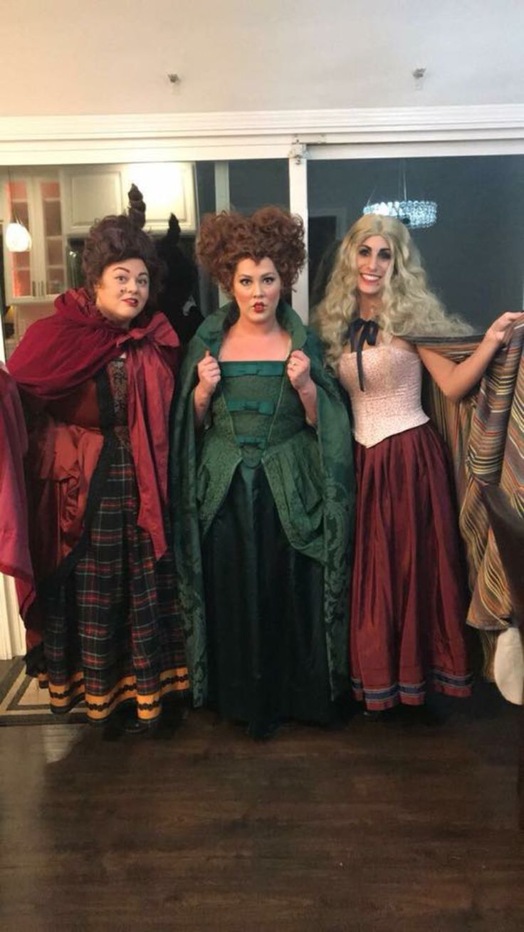 three women dressed in costumes standing next to each other