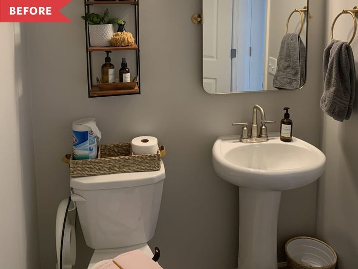 a white toilet sitting next to a bathroom sink under a mirror and hanging shelves above it