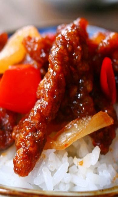 a plate with rice, meat and vegetables on it is shown in close up view