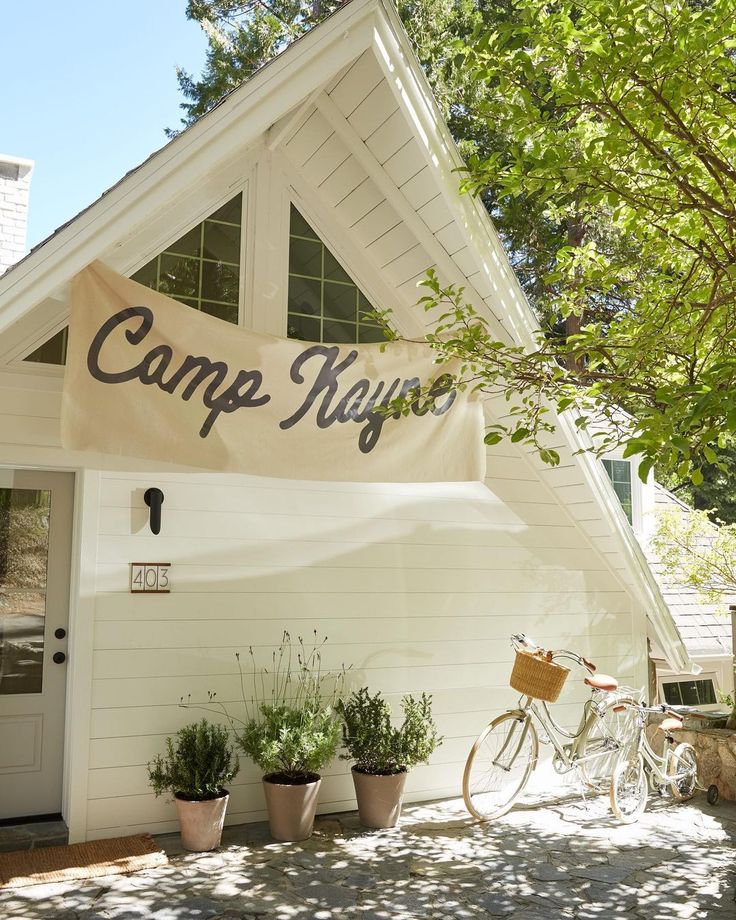 a bicycle is parked in front of a white building with a sign that says camp neugo