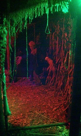 a group of people standing in the dark under a tent with red lights on it