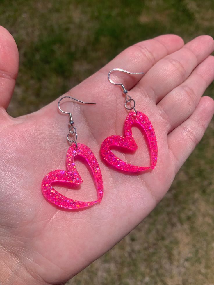 Each pair of resin earrings are made to order, therefore no two pairs are identical! However, I try to get as close as possible :) Made with nickel free, hypoallergenic, sterling silver plated fish hooks.  Heart is approximately 3cm x 3cm and is made with epoxy resin and neon pink holographic mix glitter  💖 Please note that the hearts will hang at an angle. Thanks for visiting my shop! ✨ Neon Earrings, Pink Holographic, Rave Accessories, Resin Ideas, Fish Hooks, Glitter Earrings, Pink Car, Holographic Glitter, Resin Earrings