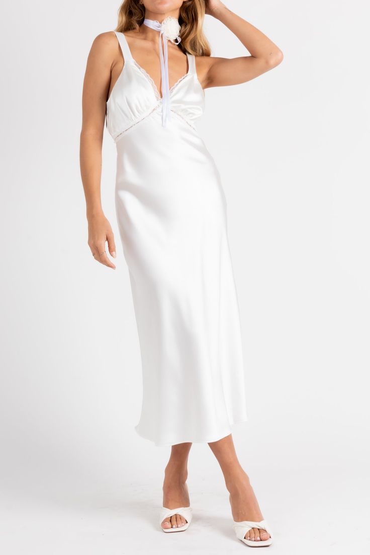 Giving us angel energy with a bit of spice. The Ethereal Slip Dress is the dress of the season! Made from satin with lace trim, open back detail and a midi length. Color: White Satin Midi Length Lace Trim Open Back With Button Closure Polyester Lined Model Is 5'5", 24/25 Waist, 32A Bust & Wearing Size Small Evening Satin Midi Dress With Lace Trim, Satin Midi Dress With Lace Trim For Evening, Satin Midi Dress With Lace Trim, Satin Midi Length Dresses With Lace Trim, Fitted Satin Midi Dress For Night Events, Fitted Satin Midi Dress For Night, Spring Wedding Dress In Modal Satin, Spring Wedding Modal Satin Dress, White Satin Finish Dress With Spaghetti Straps