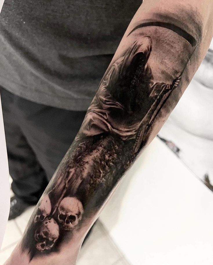 a man with a black and white tattoo on his arm holding a skull in front of him