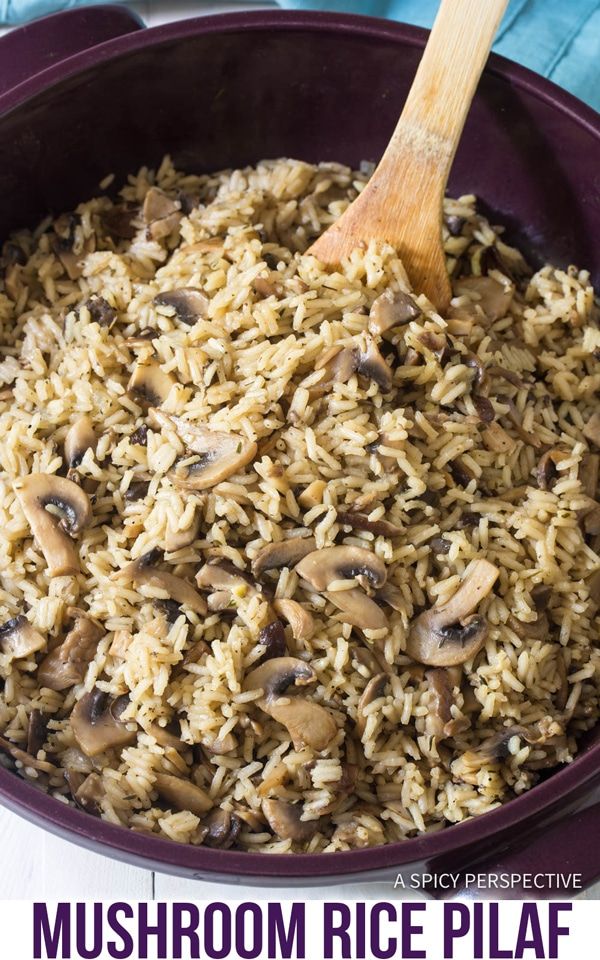 mushroom rice pilaf in a purple pan with a wooden spoon on the side