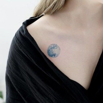 a woman with a blue moon tattoo on her chest