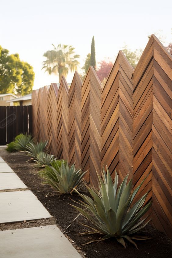 a wooden fence with succulent plants in the foreground