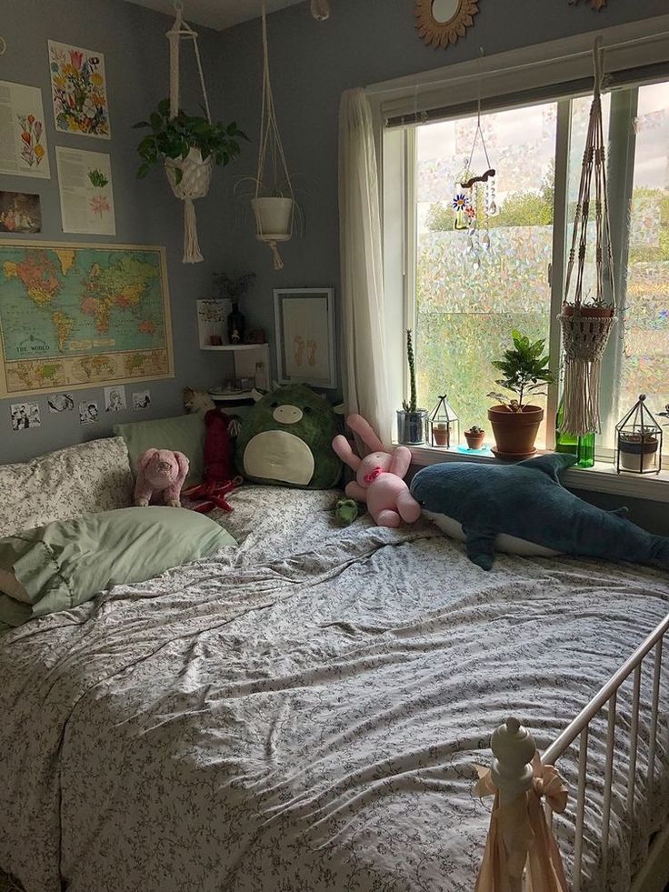 two stuffed animals laying on top of a bed in a room with a large window