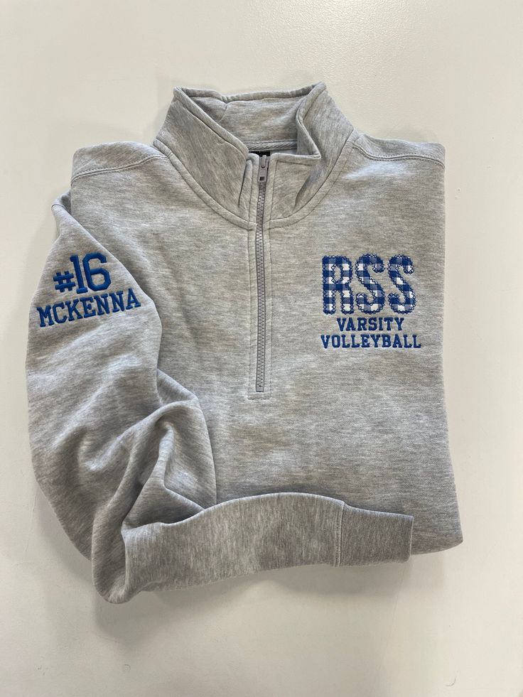 the back of a gray sweatshirt with blue letters on it and numbers printed on the sleeves