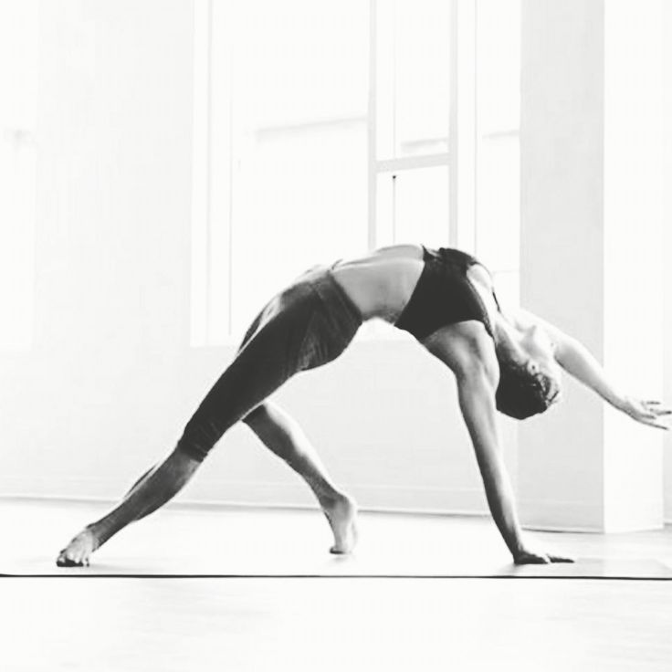 a woman is doing yoga in the middle of a room with her legs spread out